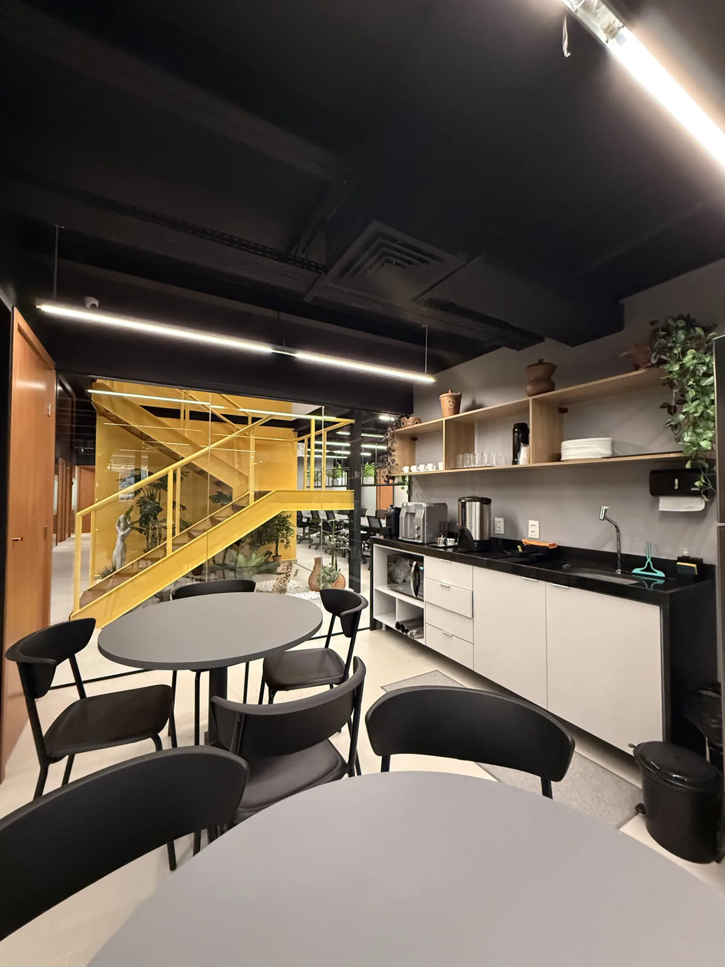 Copa equipada do coworking com café, água e mesas de apoio